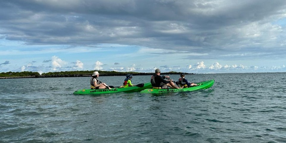 A family adventure in the Galápagos, paddling together on a kayak, surrounded by stunning scenery and wildlife